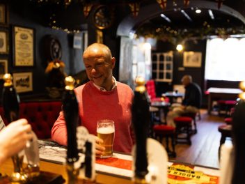 Wayne standing at bar